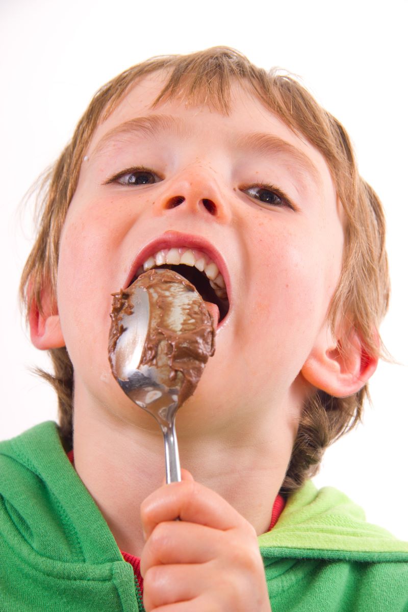 Boy licking spoon