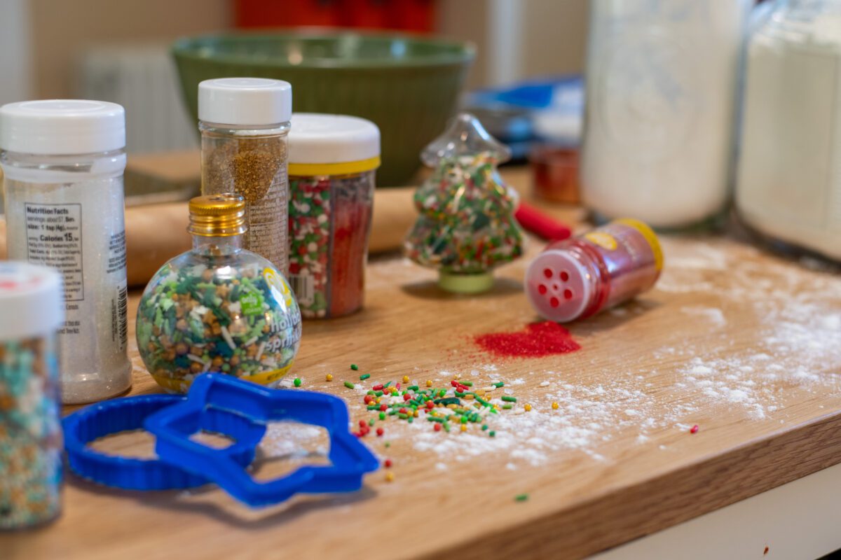 Decorative Christmas sprinkles on a flour-covered countertop. 