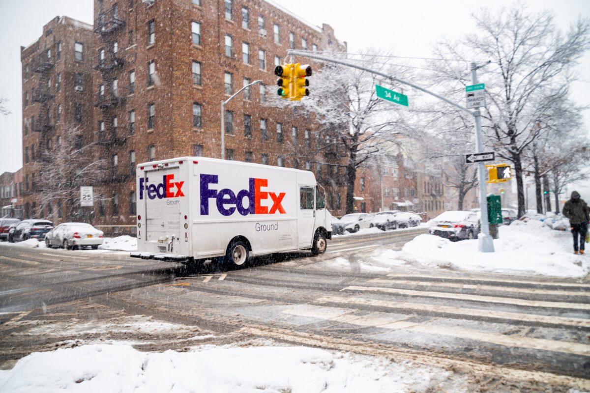 FedEx truck driving through snowy NYC.