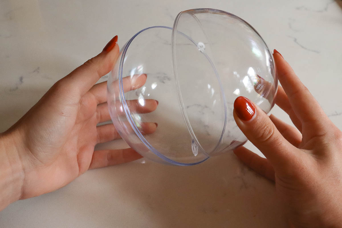 Woman's hand holding clear plastic bauble