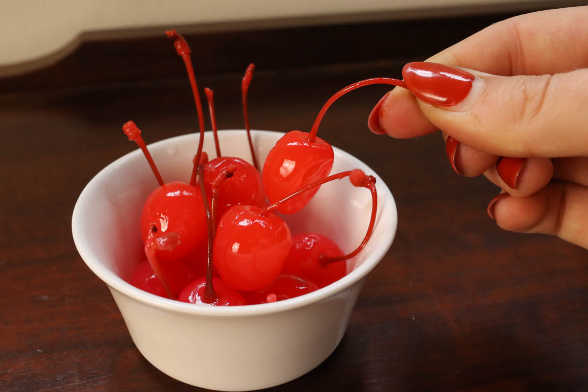 Woman's hand picking up a cherry