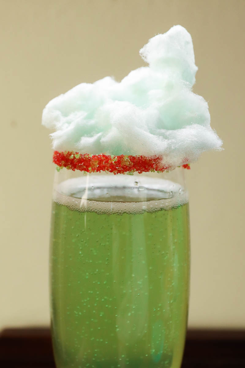 Grinch cocktail with cotton candy garnish