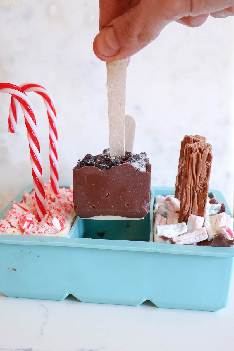 Pulling cookies and cream hot cocoa spoon out of silicone mold. 