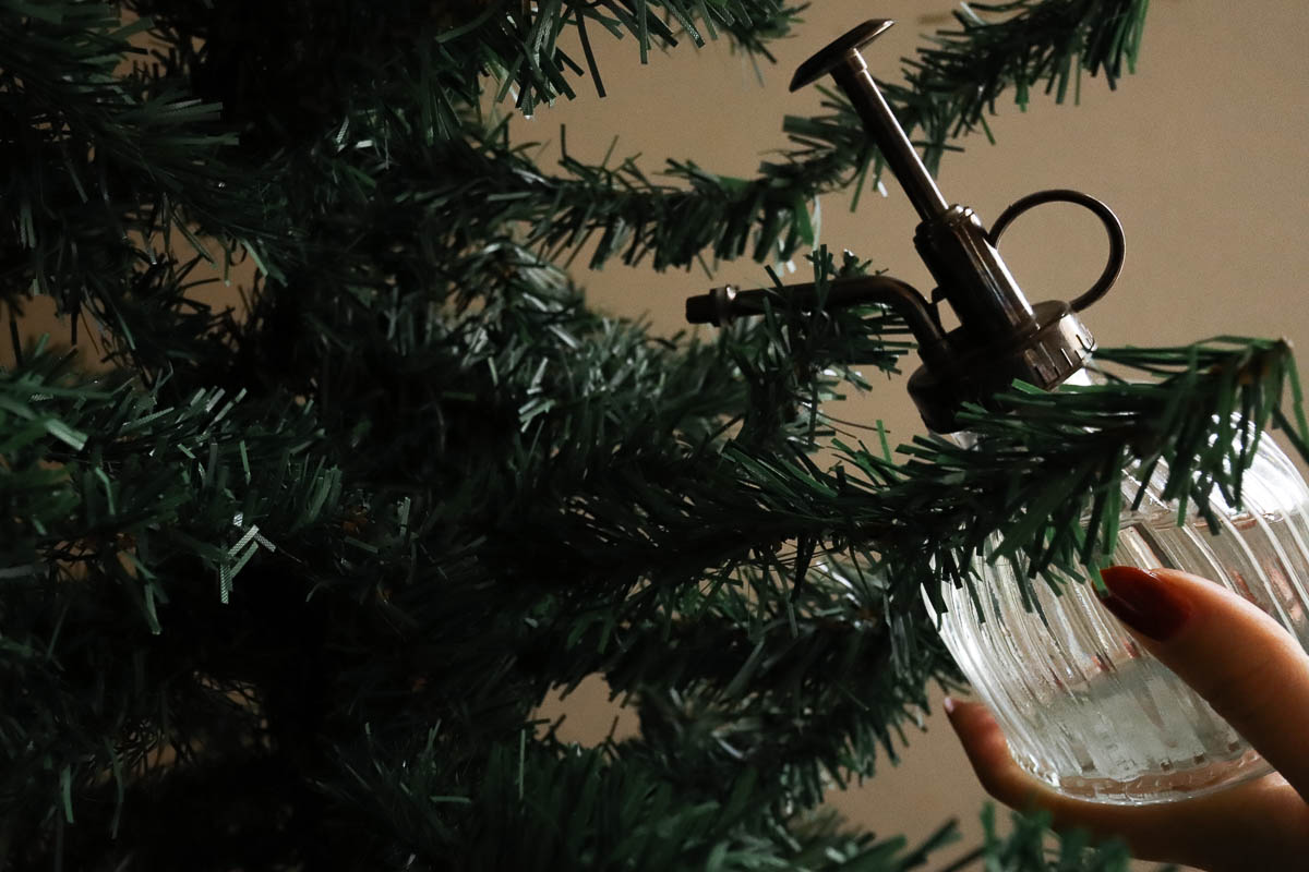 Woman spritzing a tree with homemade room spray