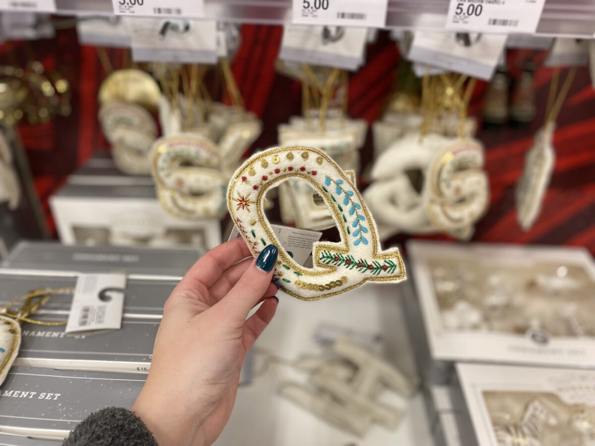 Woman's hand holding a "Q" ornament