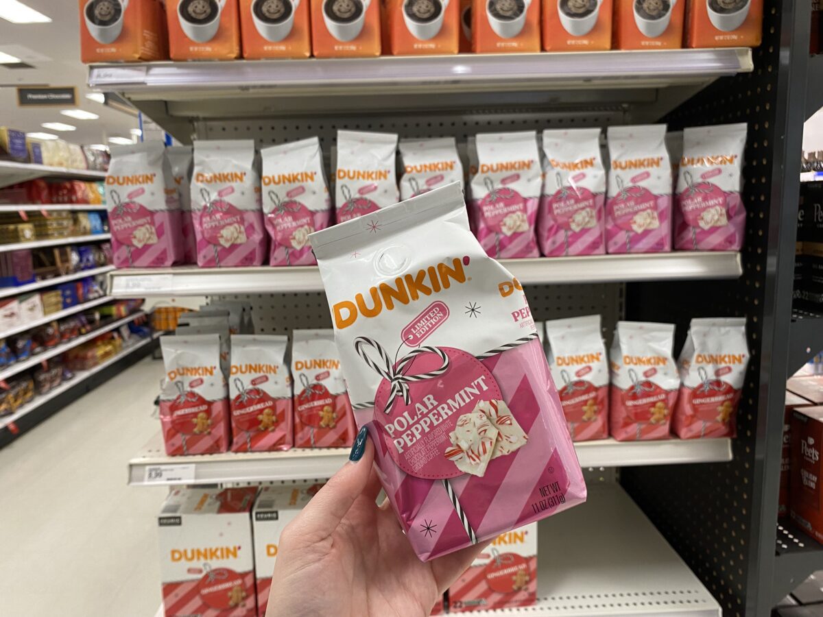 Woman's hand holding a bag of Dunkin donuts coffee