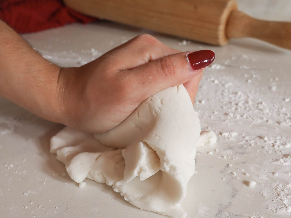 woman's hand kneading dough