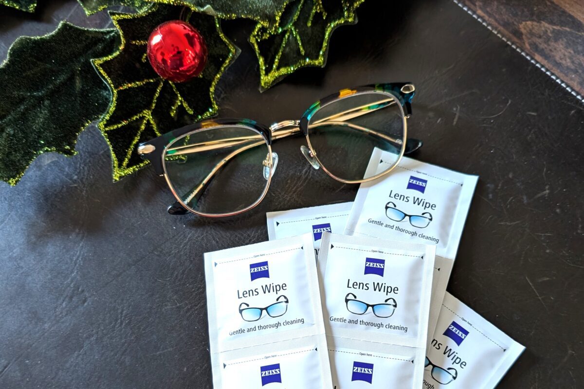 A pair of glasses next to several lens wipe packets. 