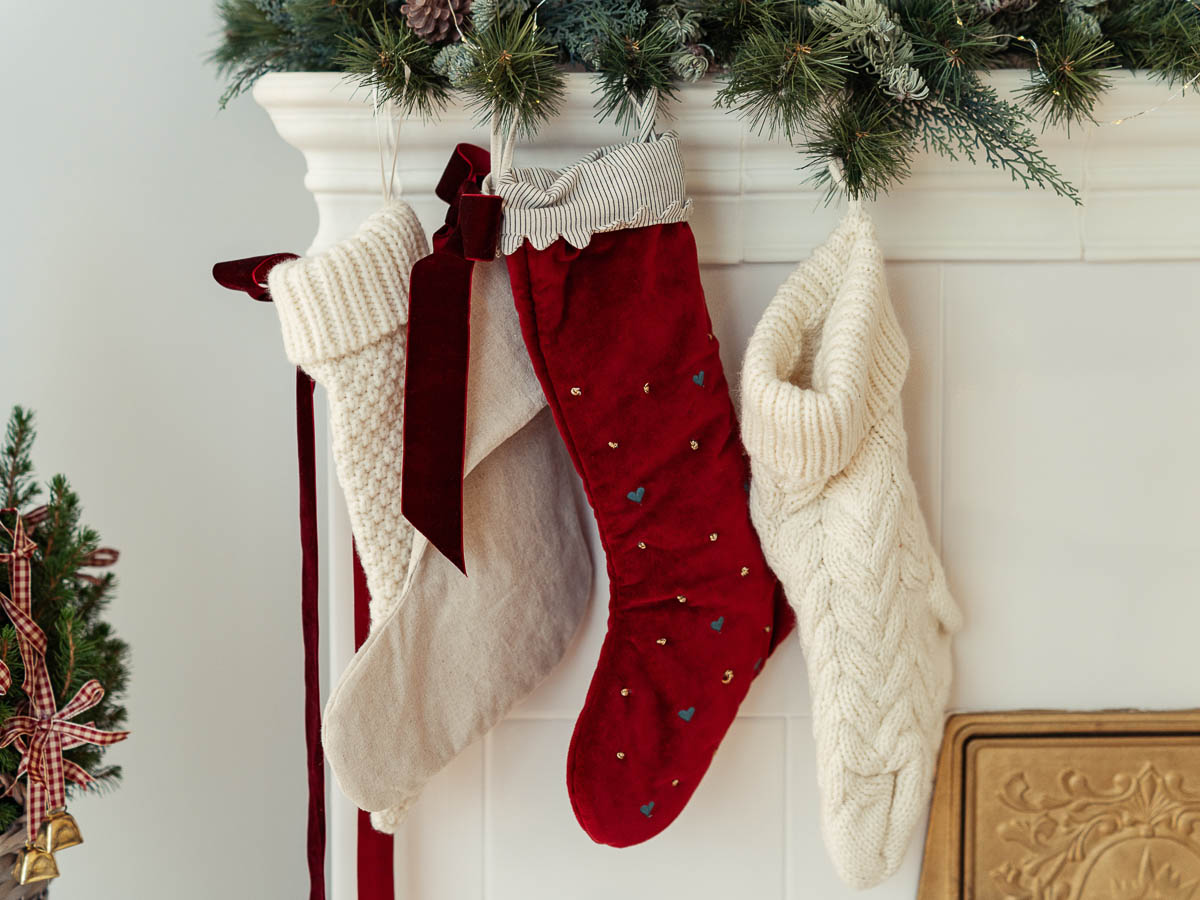 Three stockings hung next to a fireplace. 